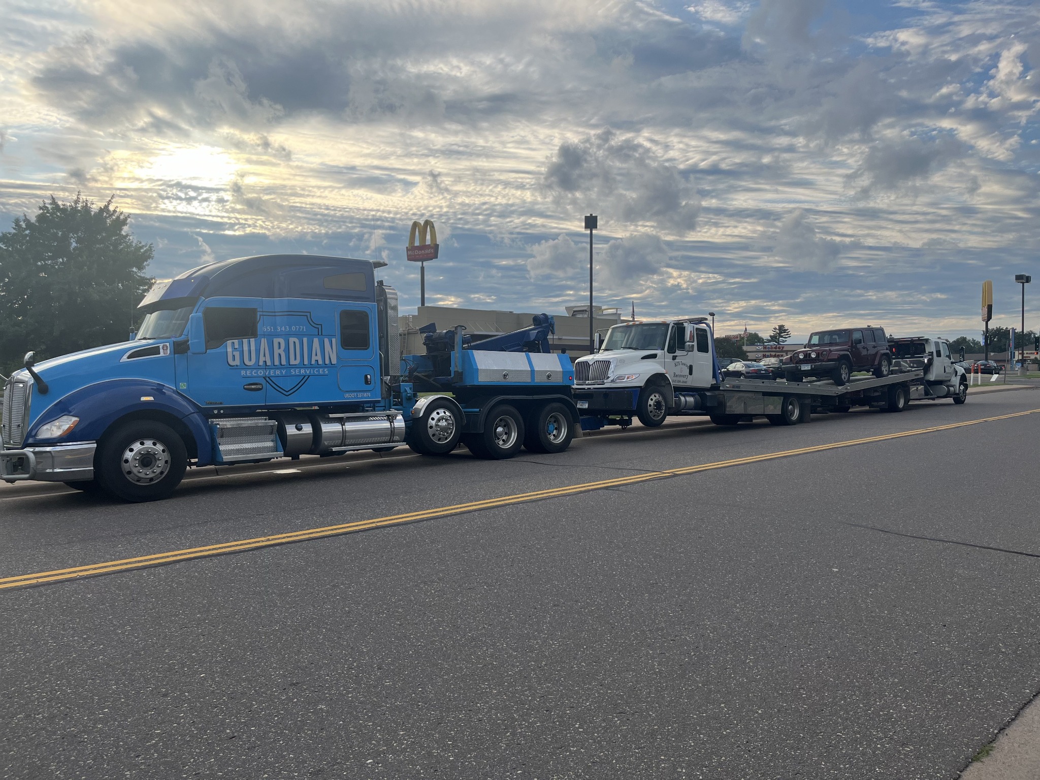 Guardian heavy-duty tow truck transporting a flatbed tow truck